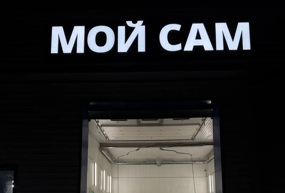 Автомойка «Мой сам» ночью: светящаяся вывеска и открытые ворота бокса